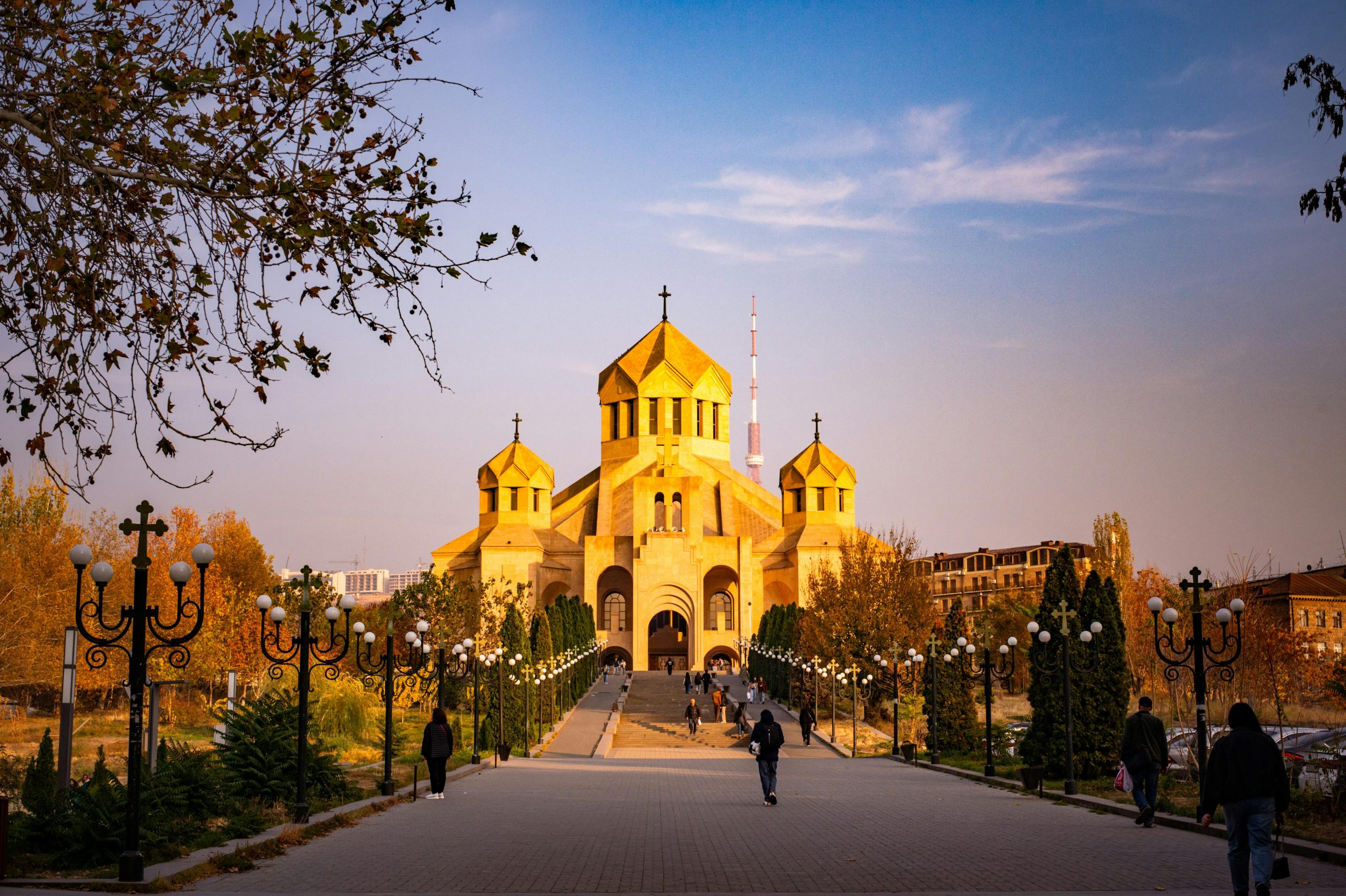 Golden hour view of Saint Gregory the Illuminator Cathedral in Yerevan, Armenia, with autumn foliage.
